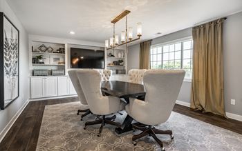 A modern dining room with a dark wood table and two chairs